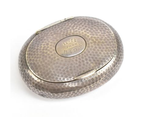 An Edward VII hallmarked silver tobacco box of oval form, with planished decoration surrounding an oval cartouche with engrav