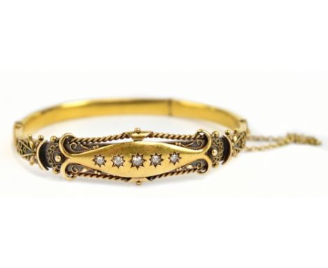 A late Victorian/Edwardian 15ct yellow gold filigree decorated and five stone diamond hinged bangle, internal width 6cm, appr