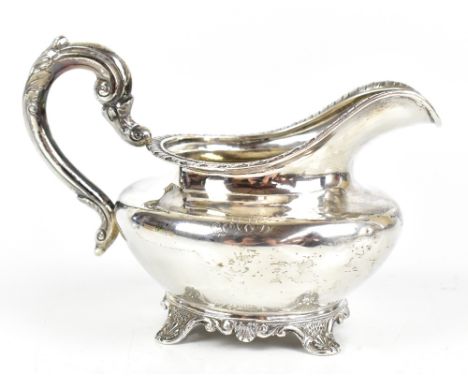 JAMES MOORE &amp; EDWARD MURRAY; a Victorian hallmarked silver cream jug of squat form with a cast rim, raised on four outswe