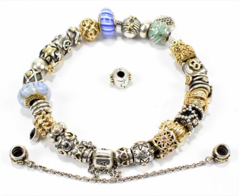 PANDORA; a hallmarked silver charm bracelet featuring seven yellow metal charms all stamped 585 and further silver and silver