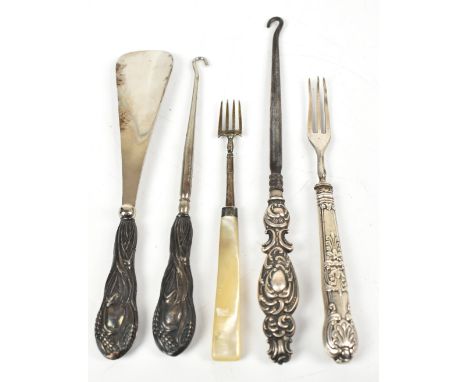 Two silver sheath handled button hooks, a silver sheath handled shoe horn, a silver sheath handled small fork and a mother of