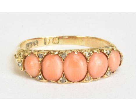 A late Victorian/Edwardian yellow metal coral and diamond chip ring set with five graduated coral cabochons and ten tiny diam