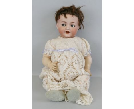 A Kammer and Reinhardt Simon and Halbig bisque head doll, with applied hair, flirty eyes, open mouth with teeth and trembly t