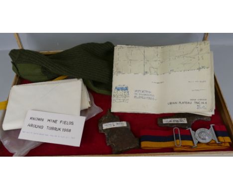 A table top cabinet, containing various military items, including RAMC belt, army olive drab jersey, various folding maps, tw