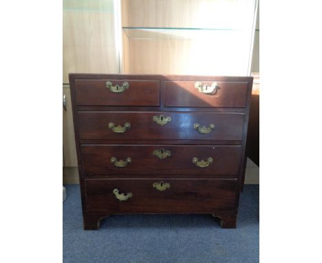 A George III mahogany five drawer chest with brass drop handles on bracket feet 