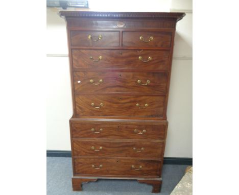 A George III inlaid mahogany chest on chest with brass drop handles raised on bracket feet 
