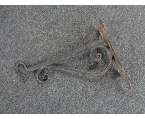An antique cast iron wall bracket with hook 