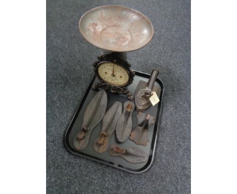 A tray containing cast flat iron, cobbler's last, vintage household No. 49 scales 
