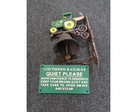 A cast iron tractor wall bracket with bell and a railway safety notice 