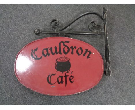 A hand painted metal Cauldron Cafe sign on bracket 