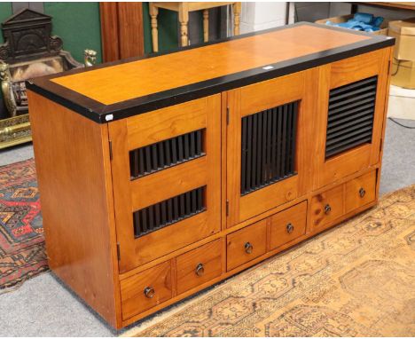 A contempory pine and part ebonised sideboard with louvre panel doors over three drawers, 148cm by 52cm by 83cm, en suite wit