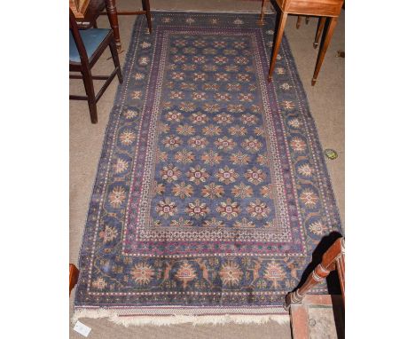 A Balouch rug, the indigo field of stylised flower heads enclosed by borders of angular vines, 288cm by 146cmCondition report