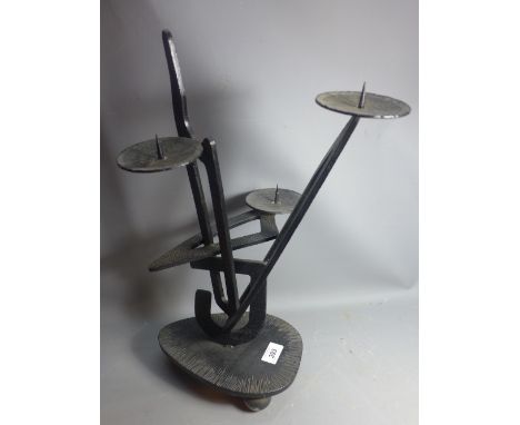 A modernist black steel candle stick holder on ball feet. 