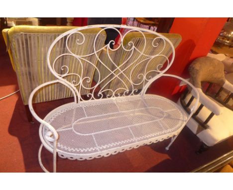 A white painted wrought iron two seater garden bench