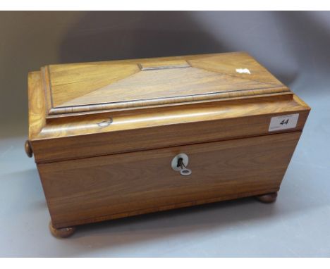 A Georgian rosewood  tea caddy in sarcophagus form on four bun feet