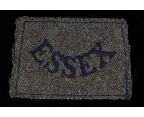World War Two embroidered slip on shoulder title to the Essex Regiment, together with a World War One economy cap badge to th