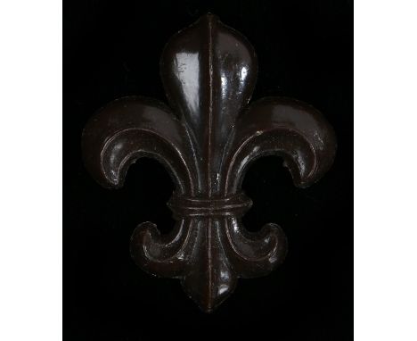 World War Two plastic economy cap badge to the Manchester Regiment, in chocolate brown, two blades to the reverse, K&amp;K 22