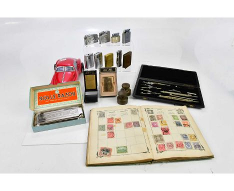 An assortment of collectors' items including Rolls razor, cast metal weights, a collection of cigarette lighters, a trench ar