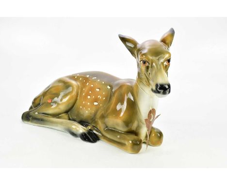 A large modern ceramic model of a recumbant doe, length 58cm.