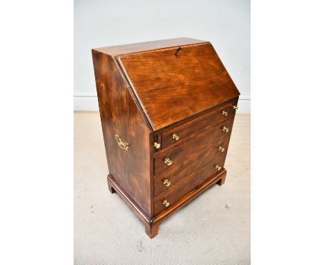 A reproduction bureau, the fall front enclosing fitted compartments and drawers above four drawers, on bracket feet, width 64