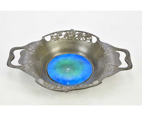 ARCHIBALD KNOX FOR TUDRIC PEWTER; a twin handled bowl with pierced body and central green/blue enamel panel, made for Liberty
