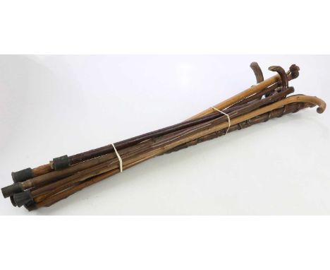 A small collection of walking sticks including a carved example and sword stick.