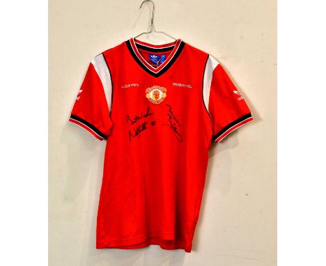 MANCHESTER UNITED; a 1985 retro style football shirt, signed to front by Norman Whiteside and Bryan Robson, size M.Condition 