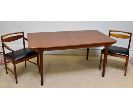 A mid century teak extending dining table on turned column legs and six dining chairs with black leatherette seats. Condition