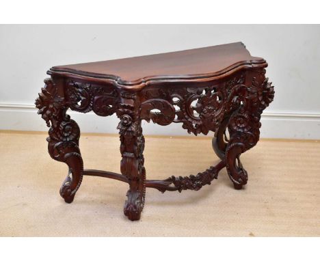 A reproduction carved serpentine fronted console table, width 130cm, depth 55cm, height 80cm.