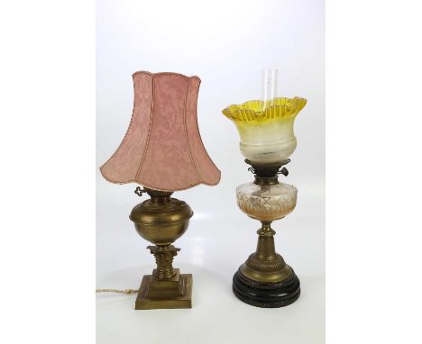 A Victorian brass oil lamp with cut glass font and yellow shade, together with a converted brass oil lamp, height of larger 6