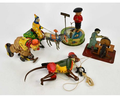 A small collection of tinplate toys including a Lehmann monkey, fisherman, clown on cart, blacksmith and roller skating clown