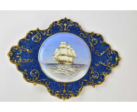 J A BAILEY FOR AYNSLEY; a rare ceramic wall plaque of shaped oval form, the centre painted with a galleon inside a gilt scrol