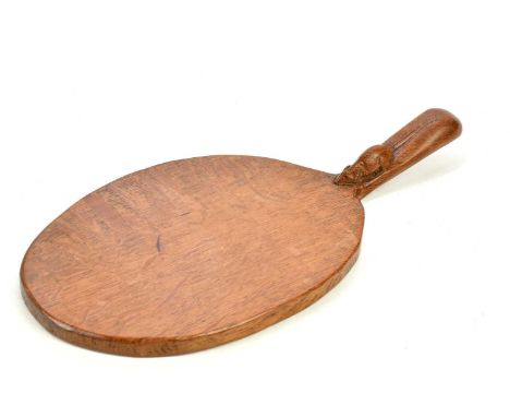 WORKSHOP OF ROBERT MOUSEMAN THOMPSON; an oak cheeseboard of oval form, with carved mouse to handle, length 37cm.