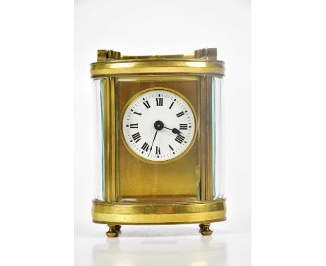 A late 19th century brass oval carriage timepiece, enamel dial with Roman numerals, height handle down, 12cm.Condition Report