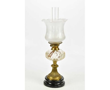 A late Victorian oil lamp with frosted glass shade above the faceted cut glass reservoir and brass fluted base, height includ