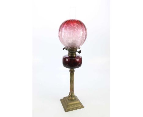 A late Victorian oil lamp with cranberry/clear glass shade with etched floral decoration, cranberry glass reservoir on fluted