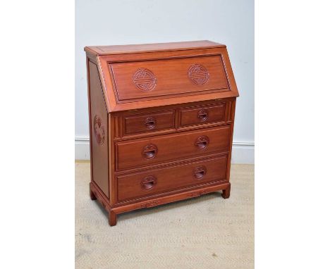 A Singapore rosewood bureau, the fall front with carved symbols, above two short and two long drawers, on bracket feet, width