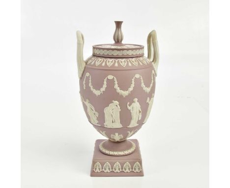 WEDGWOOD; an impressive lilac jasperware twin handled pedestal urn and cover, decorated in relief with classical figures and 