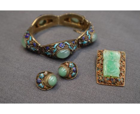 A Chinese white metal, jade and enamel panel bracelet, with  five links each set with a central cabochon jade panel surrounde
