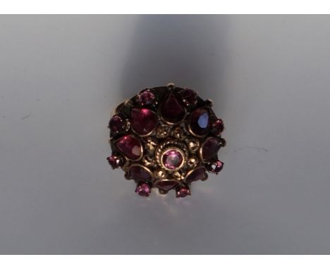 A ruby dress ring, set with pear shaped and round faceted rubies to a yellow metal setting and shank marked 18ct, approximate