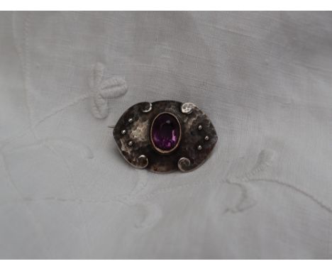 A Murrle Bennett and Co 950 standard white metal Arts and Crafts brooch, with a planished finish set with an oval faceted ame