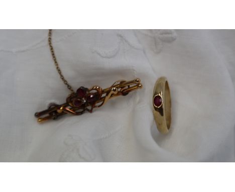 A 9ct yellow gold band with a central oval faceted ruby, size O 1/2, approximately 3 grams together with a yellow metal ruby 