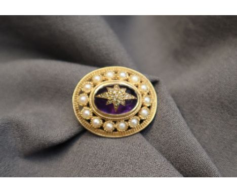 A 9ct yellow gold brooch of oval form, 34mm x 29mm set with a central cabochon amethyst topped with rose cut diamonds, surrou