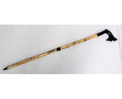 A Japanese bone sectional walking stick, with an ebony dragon carved handle, the sections carved with figures and landscape s