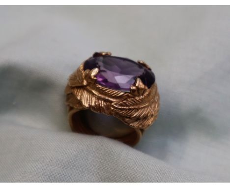 An amethyst dress ring, the oval faceted amethyst approximately 18mm x 13mm, to a yellow metal leaf cast mount and wirework s