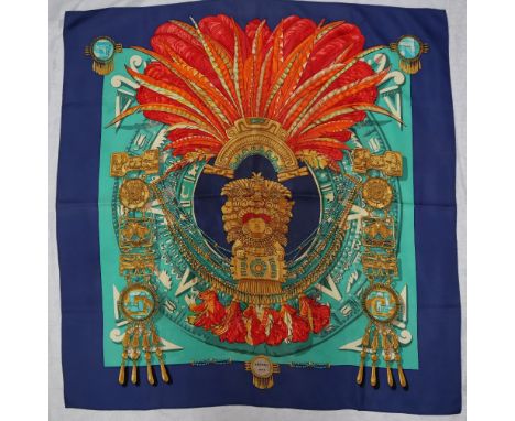 A Hermes silk scarf, decorated with a feather headdress and idol, South American inspired design, boxed