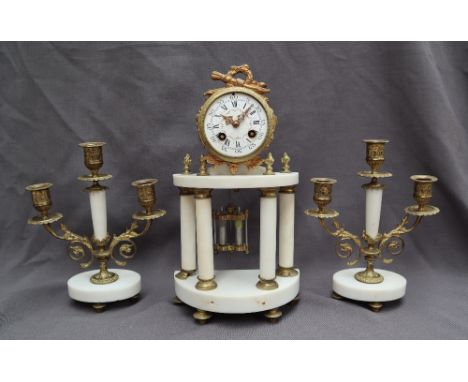 A 19th century French gilt metal and alabaster clock garniture, with drum shaped clock with quiver and wreath surmount, the w