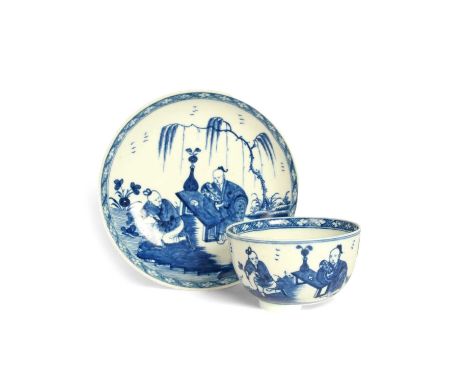 A Worcester blue and white teabowl and saucer, c.1765, painted with the Gardener pattern, a Chinese figure digging the ground