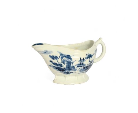 A rare Longton Hall blue and white sauceboat, c.1755-58, the generous form painted with a zigzag fence and pine tree beside a