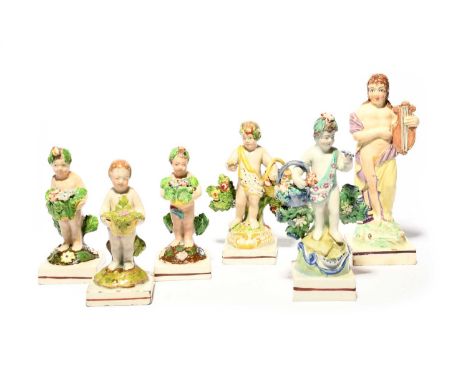 Five small Staffordshire figures of putti, early 19th century, variously modelled with baskets of flowers, raised on square b